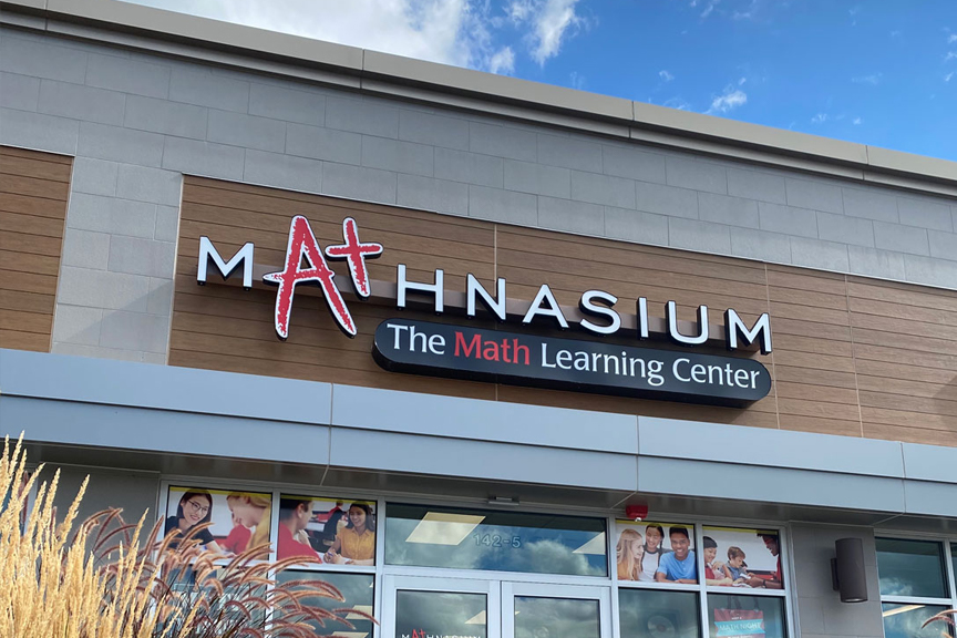 Red and white Mathnasium signage and building exterior against a bright blue sky.