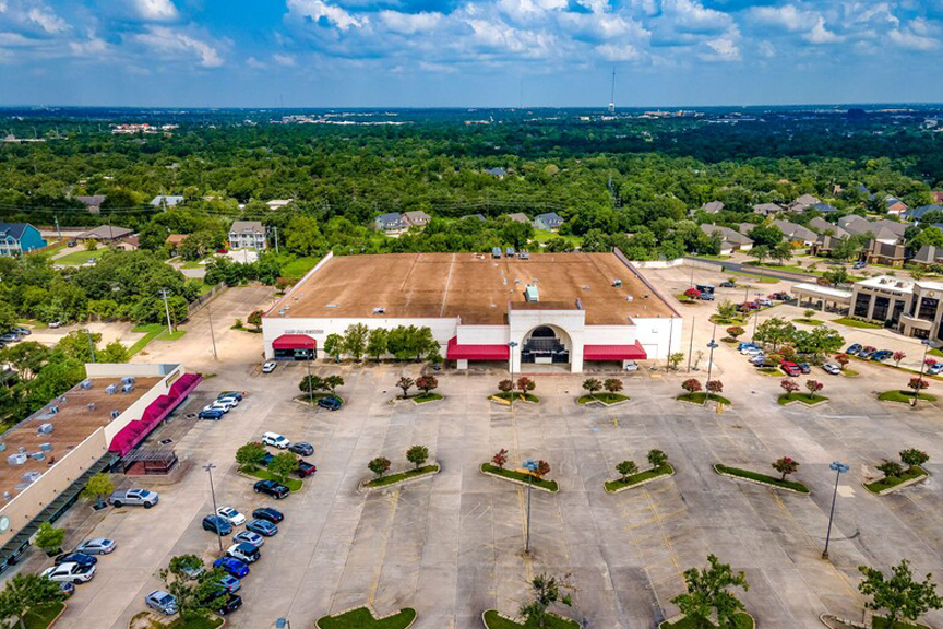 Aerial view of a large shopping center on a sunny day in College Station, TX.